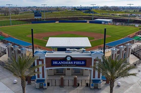 Aerial view of a baseball stadium with a green diamond, surrounding stands, and a blue-brick entrance labeled Islanders Field.