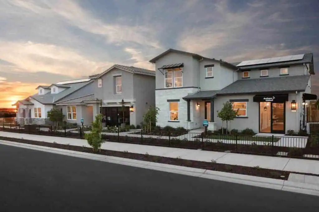 Haven and Reflections Architecture Blog River Islands Row of modern gray townhomes along a sidewalk at sunset with solar panels on the roofs
