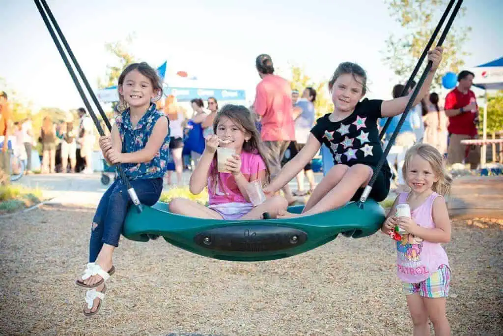 A group of children growing up in River Islands hanging out on a swing