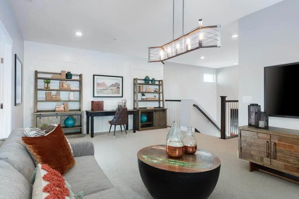 4AUHLathropHavenPt21021editWEBgeo River Islands a modern living area with a couch a television a coffee table a desk two shelves and hanging lights