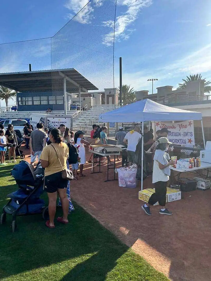 RINNOBlogPhoto2 River Islands Community outdoor event at a sports field with a blue tent people lined up for food and supplies banner reading Thank You in background