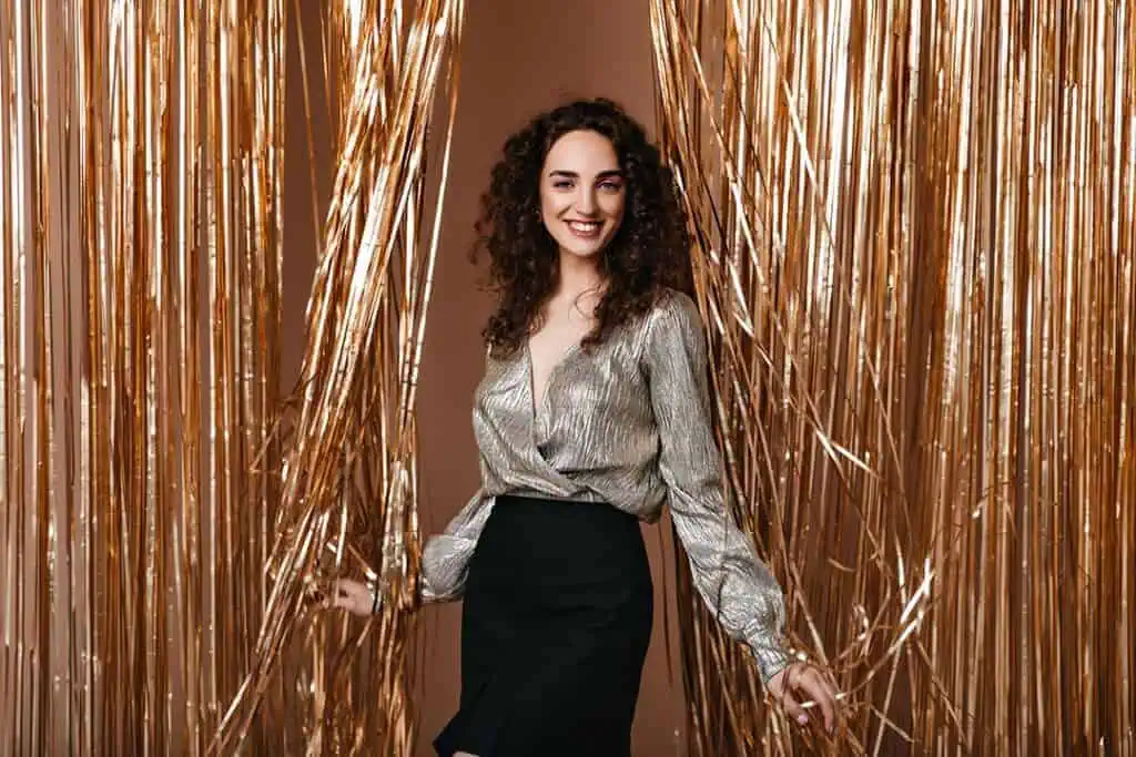 smilingwomansilveroutfithappilyposesgoldbackground River Islands people celebrating New Years Eve