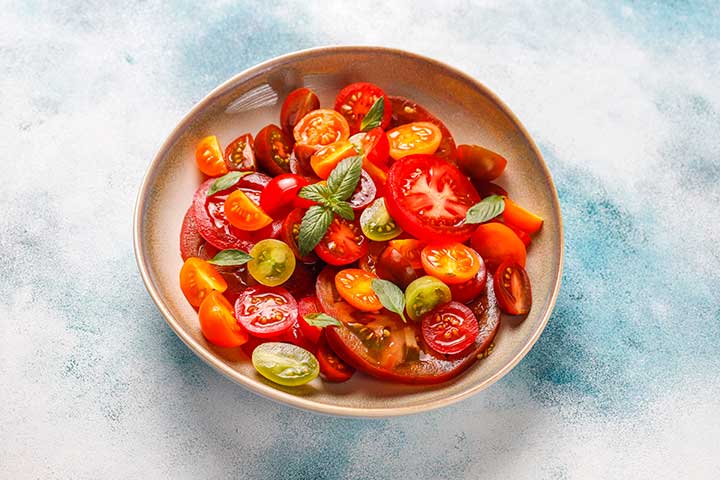 RIBlogInSeasonRecipes20230911TomBasilSalad720 River Islands heirloom tomatoes on plate