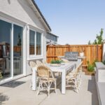 Outdoor patio of Bridgeway Plan 3501 at River Islands with dining set, BBQ grill, and privacy fencing for relaxed entertaining and family gatherings.