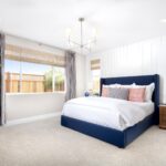 Spacious owner’s suite in Bridgeway Plan 3501 at River Islands, featuring a large window, stylish bedframe, and neutral-toned furnishings.