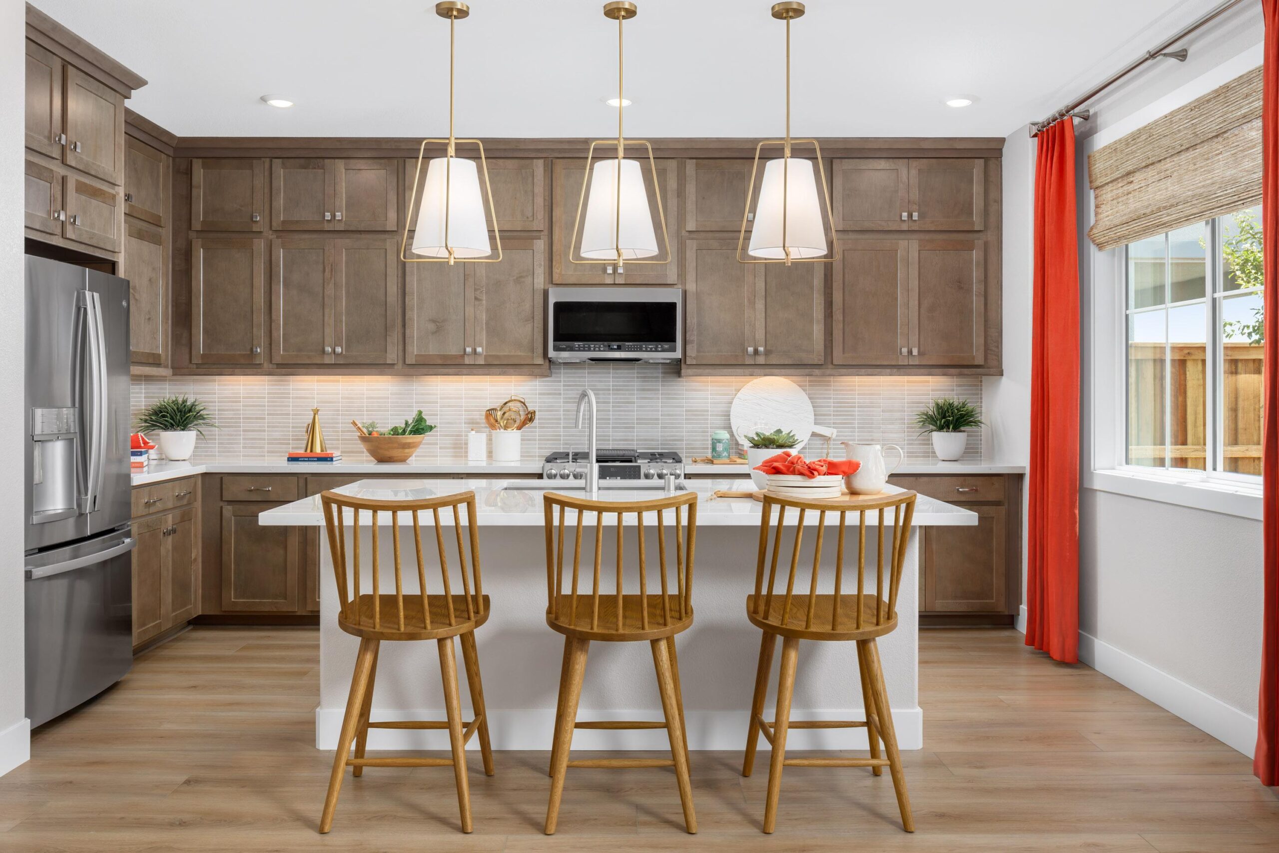 Bridgeway Plan 3502 gourmet kitchen featuring large center island, pendant lighting, stainless steel appliances, and wood cabinetry.