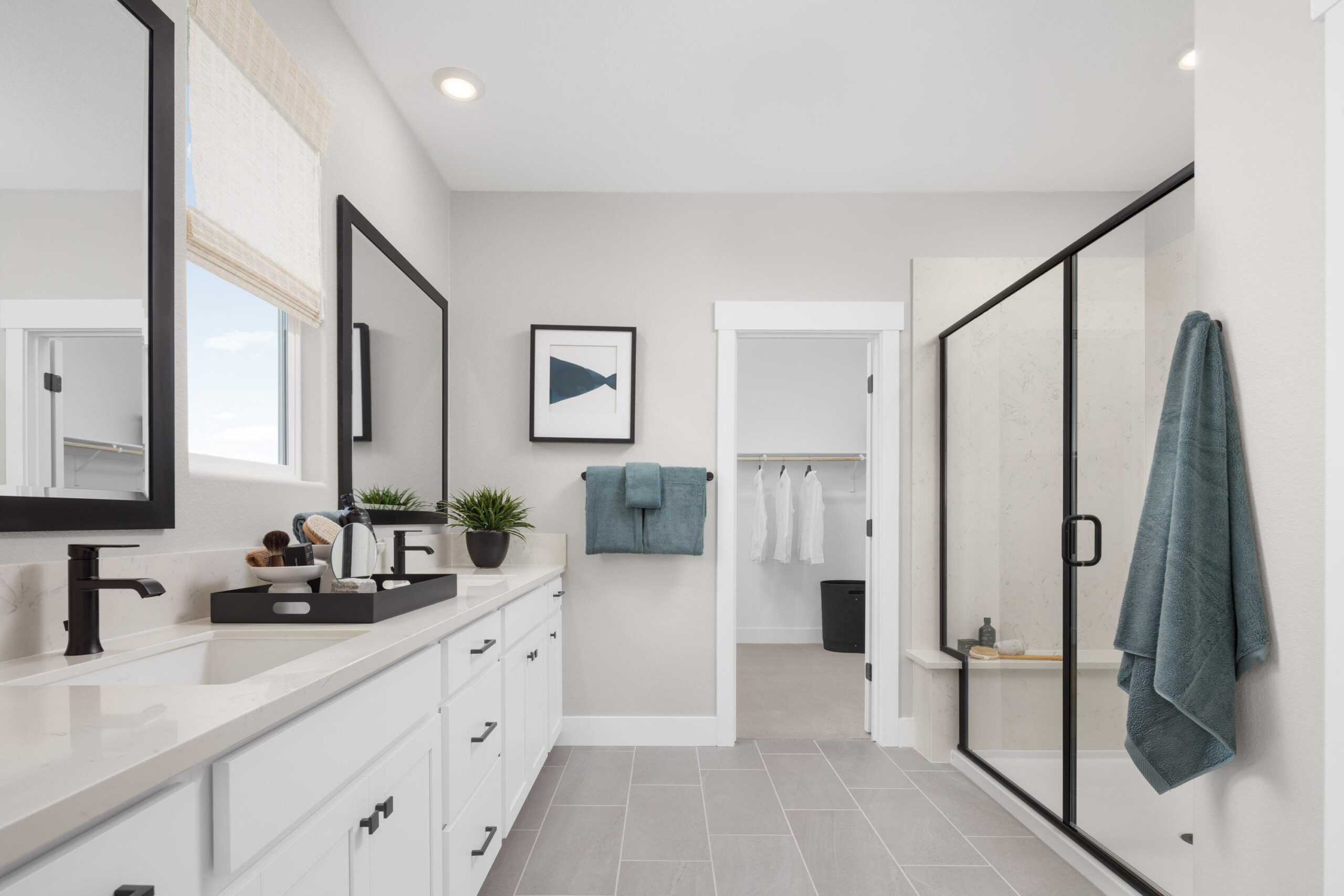 Luxurious primary bathroom in Bridgeway Plan 3503 at River Islands with dual vanities, walk-in shower, and direct access to a spacious closet.